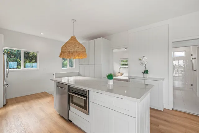a kitchen with a sink cabinets and wooden floor