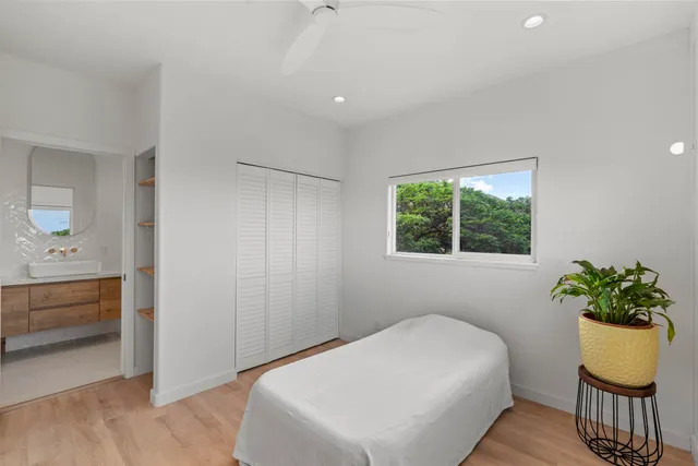 a bedroom with a bed and a potted plant