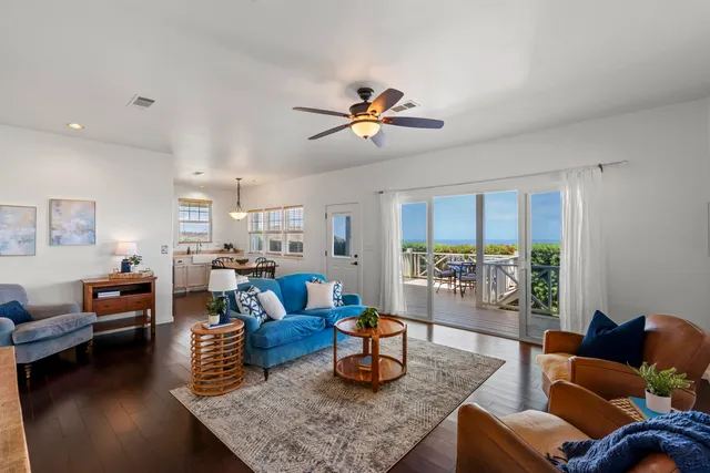 a living room with furniture kitchen view and a large window