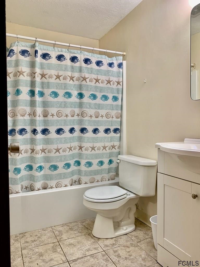 117 Queen Road St. Augustine, FL 32086 - Photo 15 of 16 a white toilet sitting next to a shower curtain