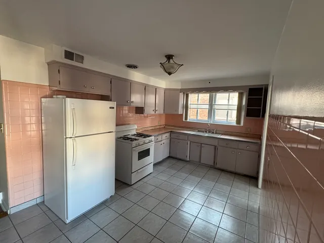 a kitchen with a refrigerator and a sink