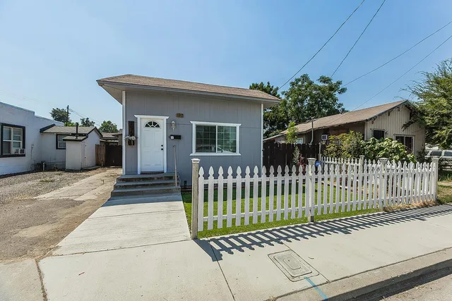 a view of a house with a wooden fence