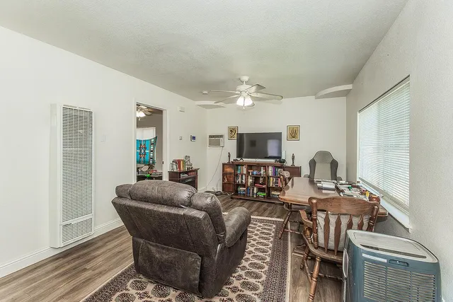 a living room with furniture a flat screen tv and kitchen view