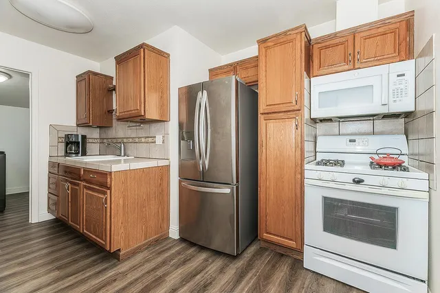 a kitchen with stainless steel appliances granite countertop a refrigerator stove and sink