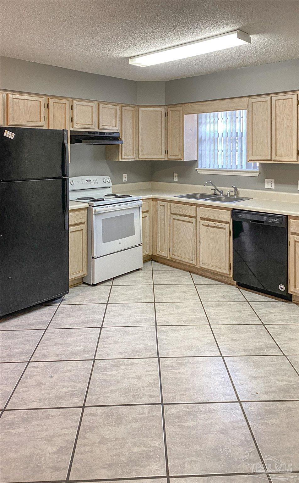 12611 Meadson Road Pensacola, FL 32506 - Photo 6 of 22 a kitchen with a stove a sink dishwasher a refrigerator and cabinets