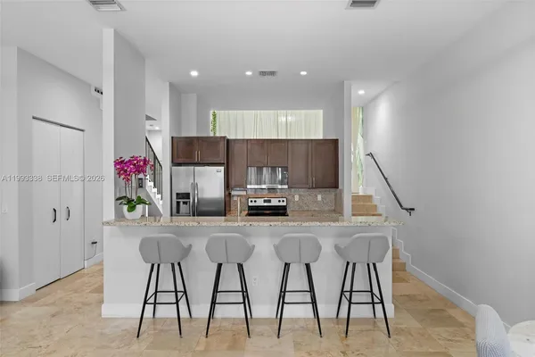 a kitchen with stainless steel appliances granite countertop a sink stove and refrigerator
