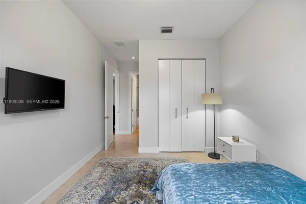 a bedroom with a bed and a flat screen tv