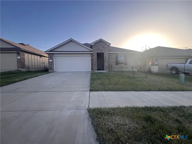 a view of a house with a yard and large trees