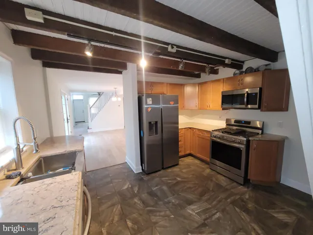 a kitchen with stainless steel appliances granite countertop a refrigerator and a stove top oven