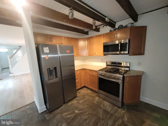 a kitchen with stainless steel appliances granite countertop a refrigerator and a stove