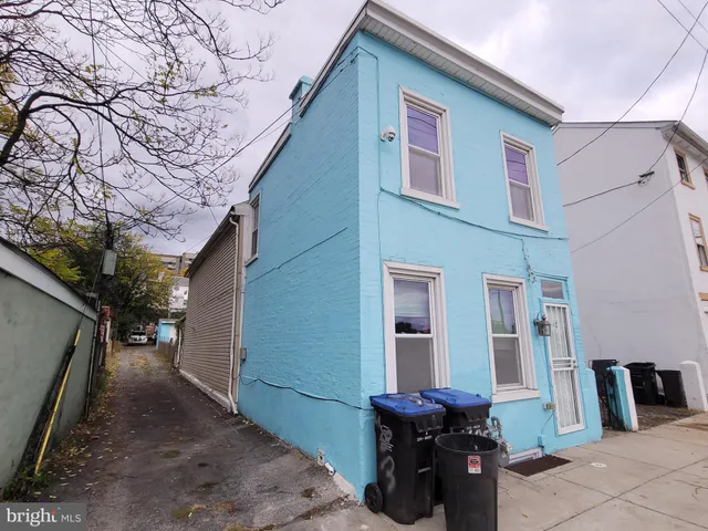 a backyard of a house with barbeque oven table and chairs