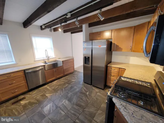 a kitchen with granite countertop a refrigerator and a stove