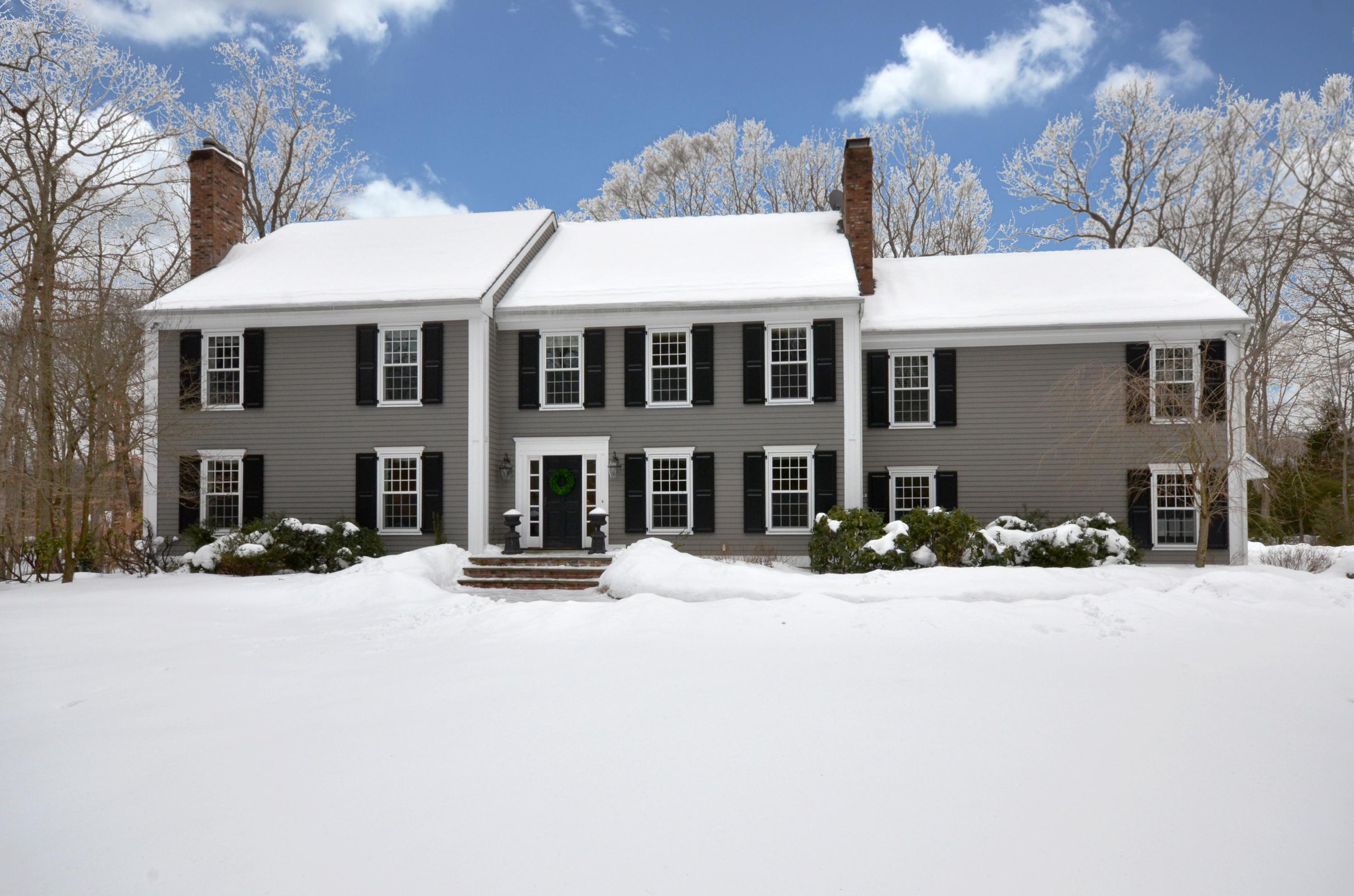 a front view of a house with a yard covered with snow