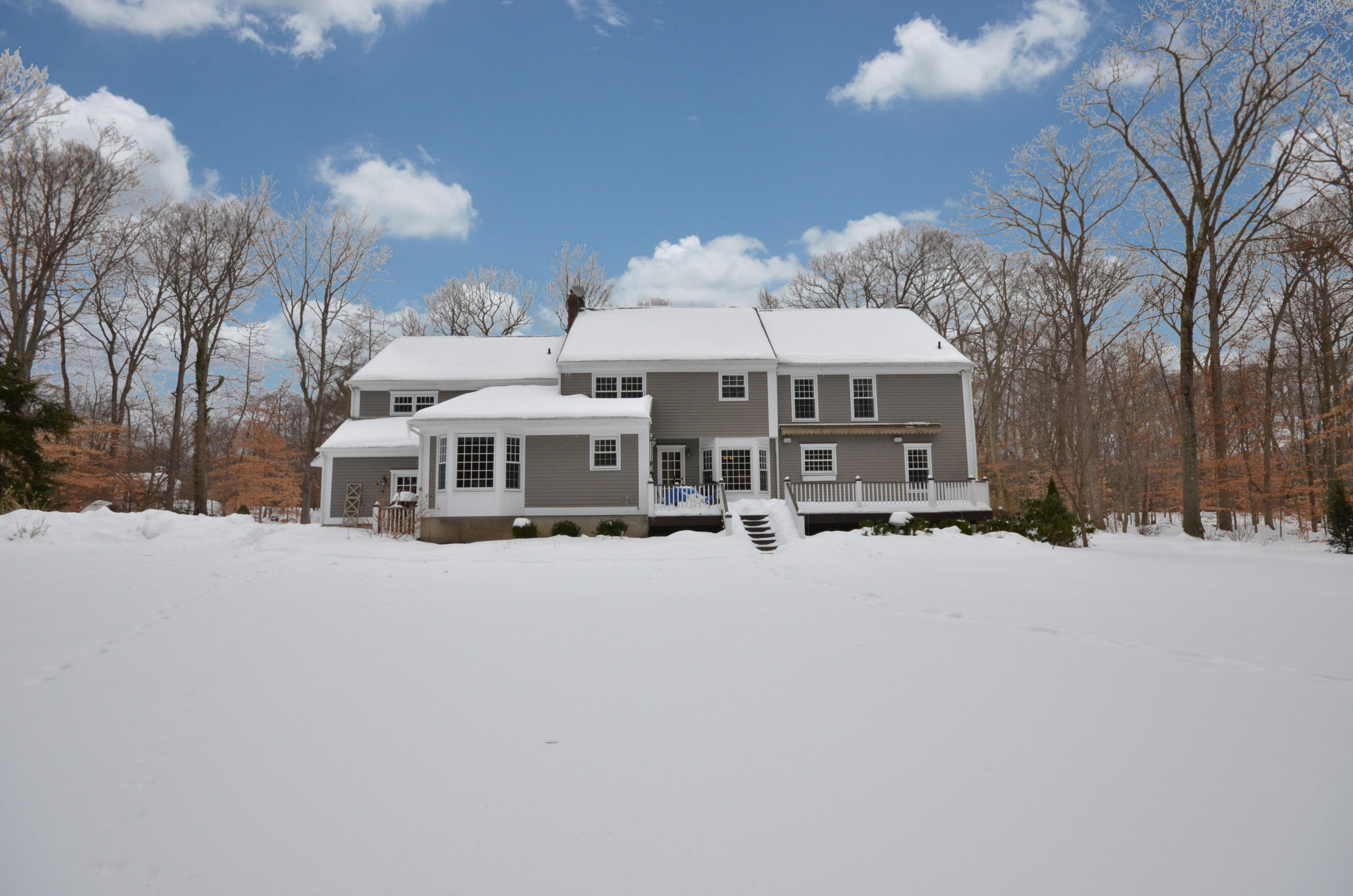 711 Hollow Tree Ridge Road Darien, CT 06820 - Photo 21 of 27 a front view of a house with a yard covered with snow and trees