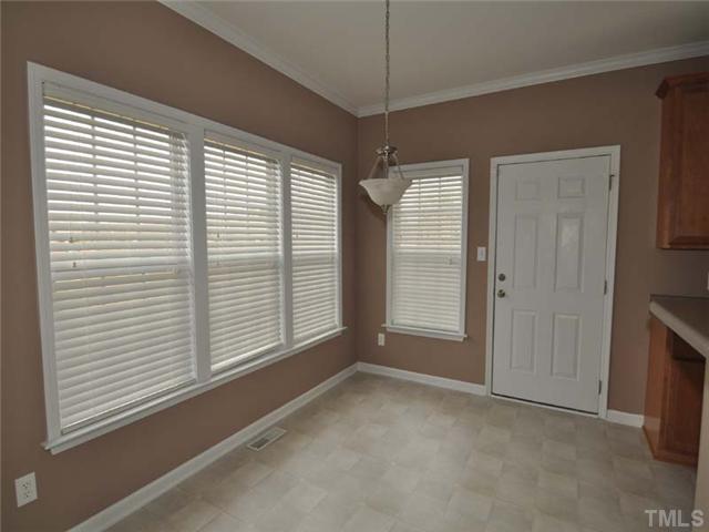 1129 Sandel Lane Raleigh, NC 27603 - Photo 7 of 12 The open breakfast nook has a wall of windows and overlooks the large fenced bedroom.