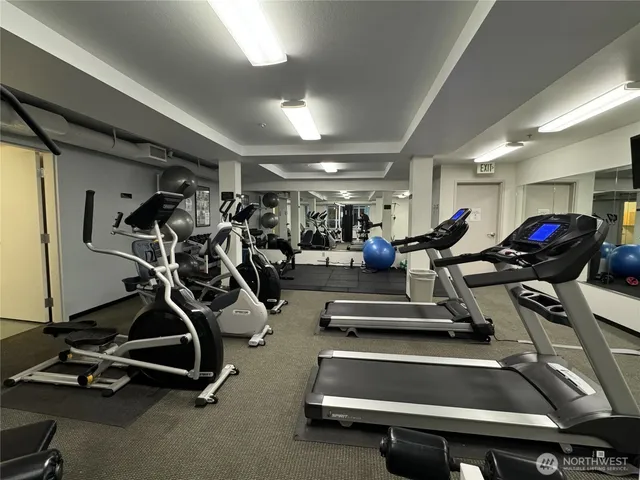 a gym room with furniture and a chandelier