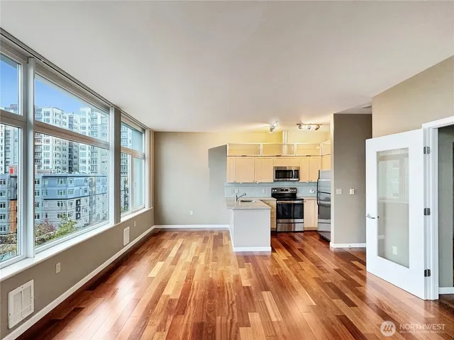 a kitchen with stainless steel appliances a large window a sink and a refrigerator