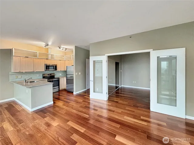 a kitchen with granite countertop a refrigerator and a stove top oven