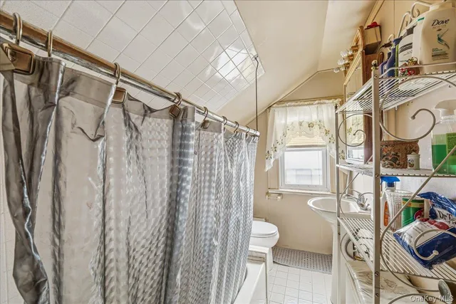 a bathroom with a shower curtain and a window