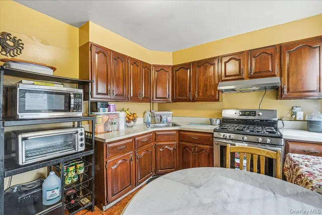 a kitchen with stainless steel appliances granite countertop a stove top oven a sink dishwasher and cabinets with wooden floor
