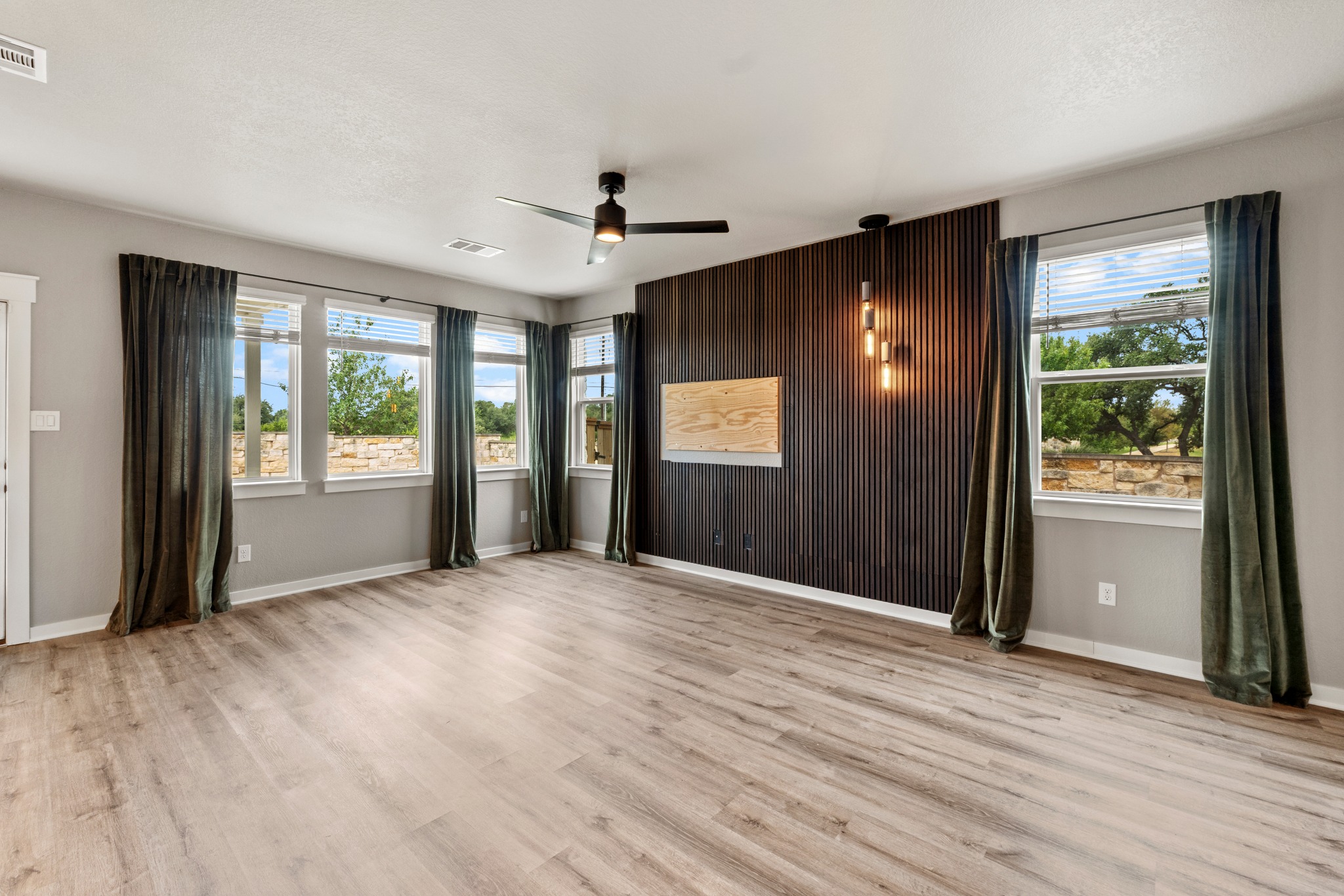 2251 Rocoso Trail Leander, TX 78641 - Photo 5 of 34 Warm wood flooring and an accent wall highlight this open living space with natural light.