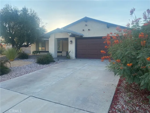 a view of a house with a yard and potted plants