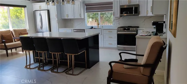 a view of a kitchen with fridge and wooden floor