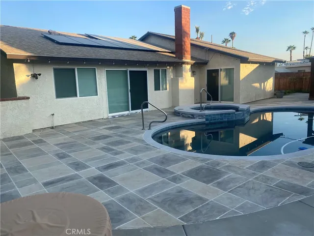 a view of a white house with swimming pool in front of it