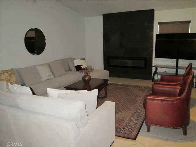 a living room with furniture and a floor to ceiling window