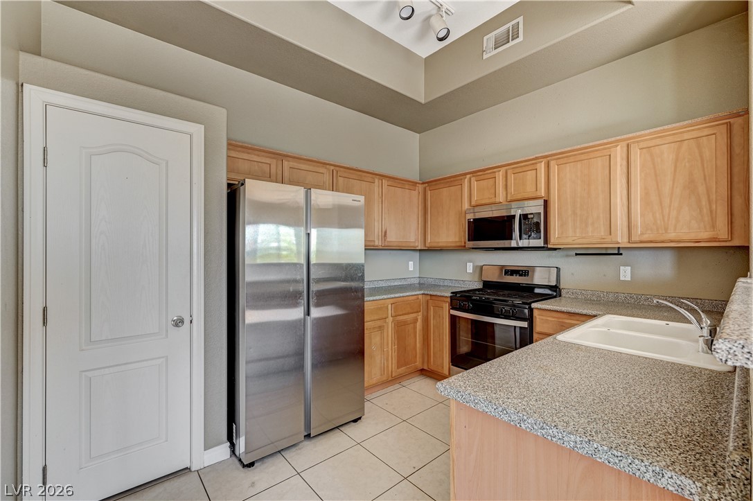 8985 South Durango Drive, Unit 2187 Las Vegas, NV 89113 - Photo 26 of 73 Culinary adventures await in this kitchen featuring abundant wood cabinetry and durable counters.