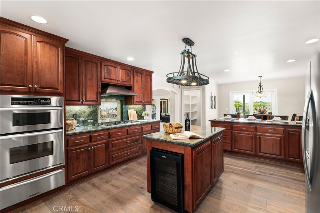 2465 Via Oeste Drive Fallbrook, CA 92028 - Photo 10 of 44 a kitchen with stainless steel appliances granite countertop a stove a sink dishwasher and a refrigerator with wooden cabinets