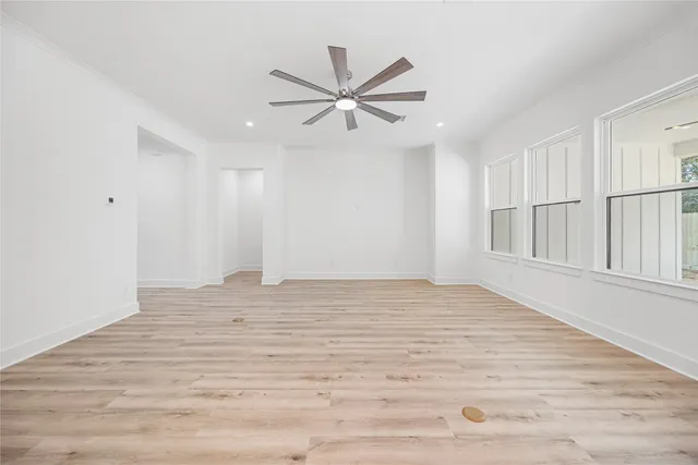 wooden floor in an empty room with a ceiling fan