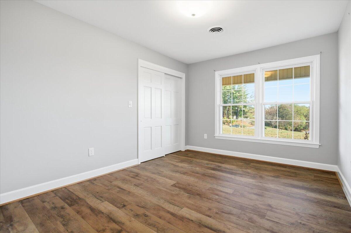 2127-2129 Moneta Road Bedford, VA 24523 - Photo 21 of 66 a view of an empty room with wooden floor and a window