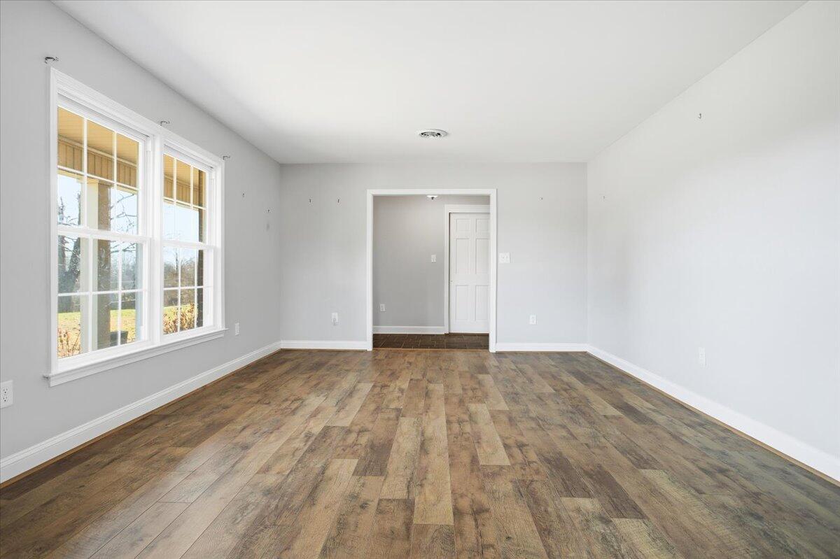 2127-2129 Moneta Road Bedford, VA 24523 - Photo 7 of 66 a view of an empty room with wooden floor and a window