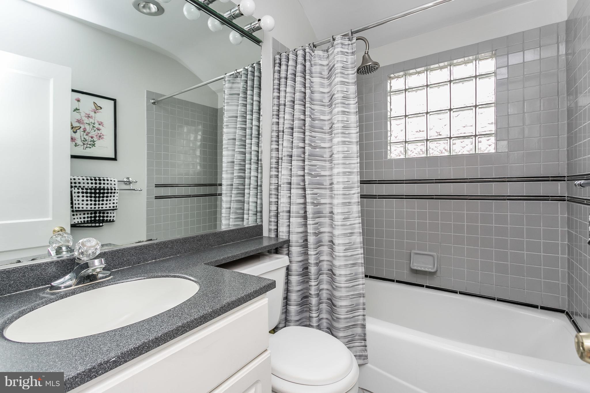 1000 Arncliffe Road Baltimore, MD 21221 - Photo 19 of 36 a bathroom with a granite countertop sink toilet a mirror and shower