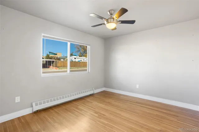 a view of a big room with wooden floor and windows