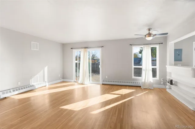 a view of a livingroom with wooden floor and a ceiling fan