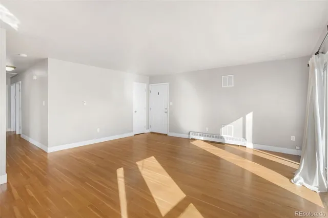 a view of empty room with wooden floor