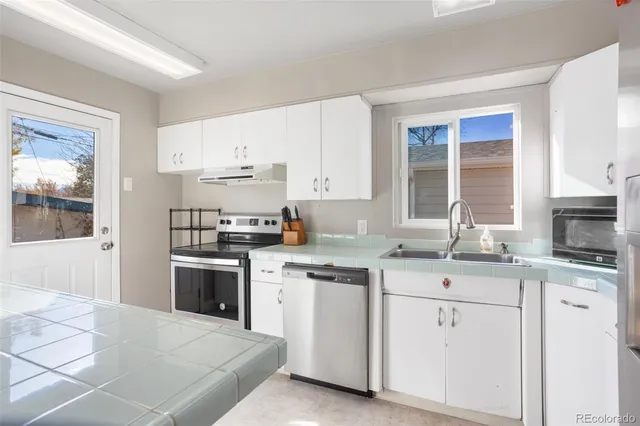 a kitchen with stainless steel appliances granite countertop a stove a sink and a refrigerator