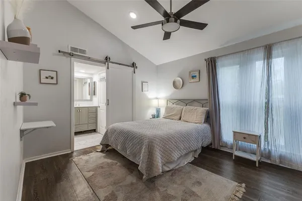 a spacious bedroom with a bed and a chandelier