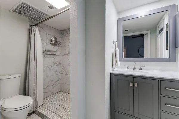 a bathroom with a granite countertop sink toilet and shower