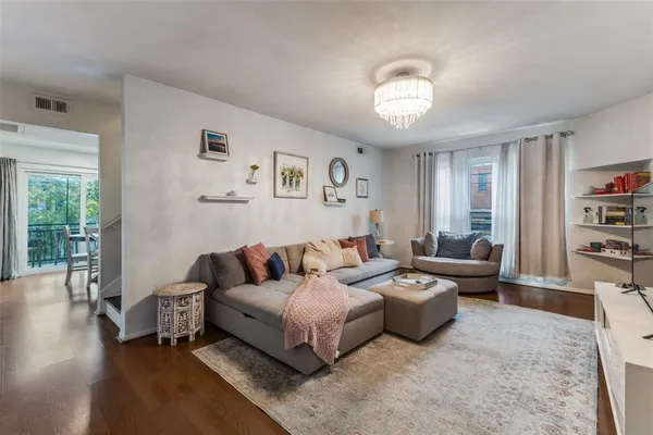 a living room with furniture a rug potted plant and a window