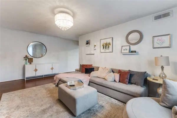 a living room with furniture a mirror and wooden floor