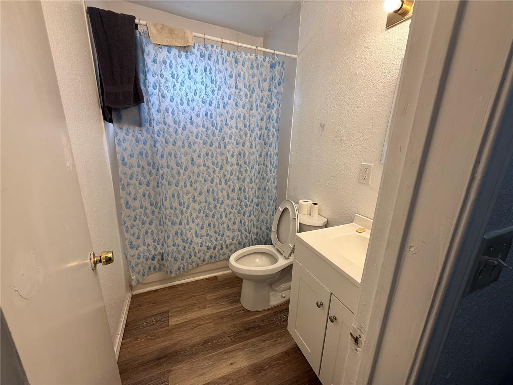 2912 Frazier Street Dallas, TX 75210 - Photo 12 of 36 a bathroom with a granite countertop toilet a sink and a shower