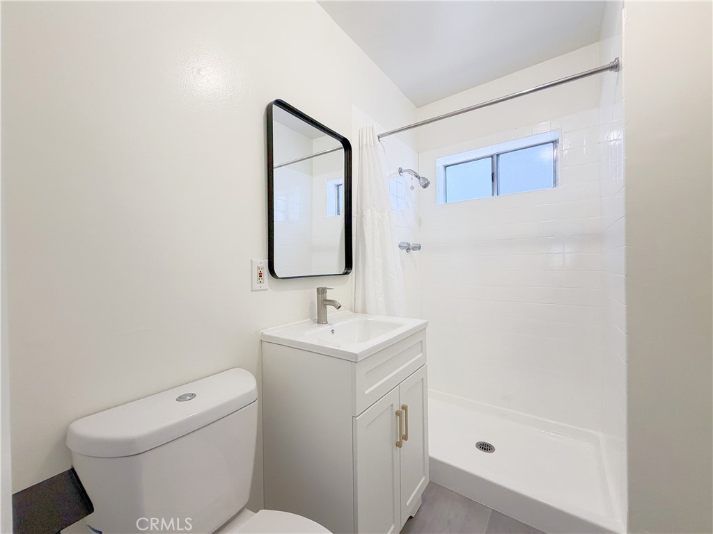 285 Parke Street Pasadena, CA 91101 - Photo 22 of 24 a bathroom with a toilet sink and mirror