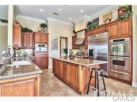 4069 Nancy Circle Corona, CA 92881 - Photo 36 of 73 a kitchen with stainless steel appliances kitchen island granite countertop a refrigerator and a stove top oven with wooden floor