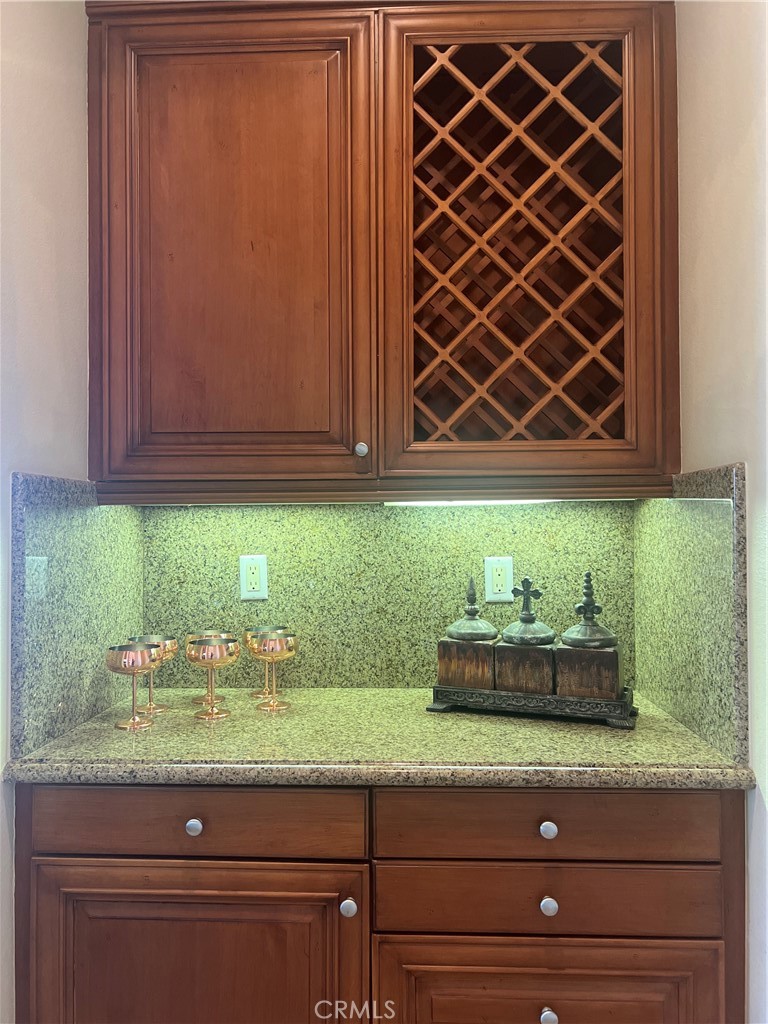 4069 Nancy Circle Corona, CA 92881 - Photo 37 of 73 a kitchen with granite countertop wooden cabinets and a potted plant