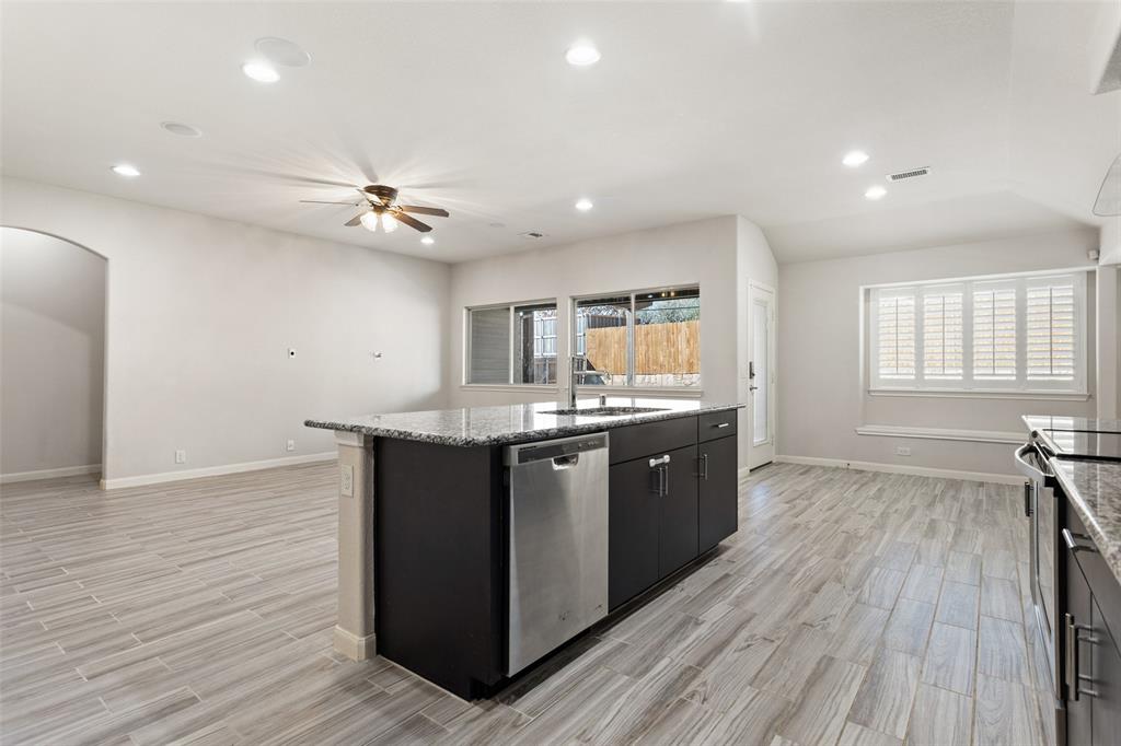 816 Harrison Lane Lavon, TX 75166 - Photo 11 of 40 a large kitchen with stainless steel appliances granite countertop a large counter top a sink and a chandelier