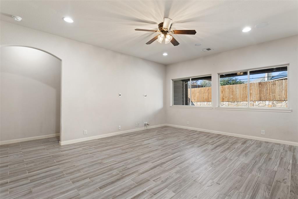 816 Harrison Lane Lavon, TX 75166 - Photo 16 of 40 an empty room with wooden floor fan and windows