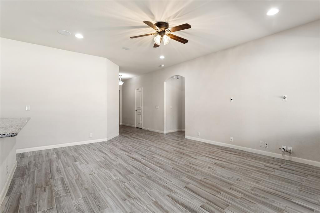816 Harrison Lane Lavon, TX 75166 - Photo 17 of 40 an empty room with wooden floor and a ceiling fan